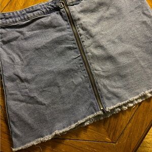 SZ 16 Denim mini skirt. Medium wash w/ zipper closure and a distressed hemline.
